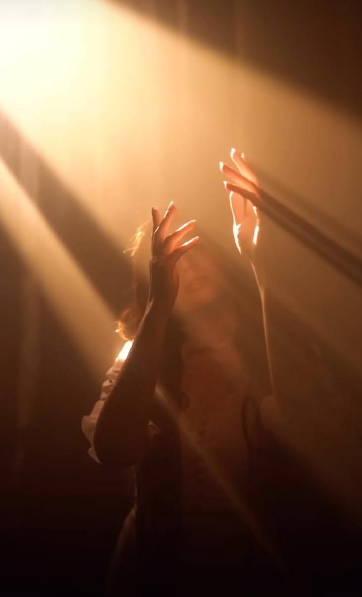A person reaching into warm rays of light